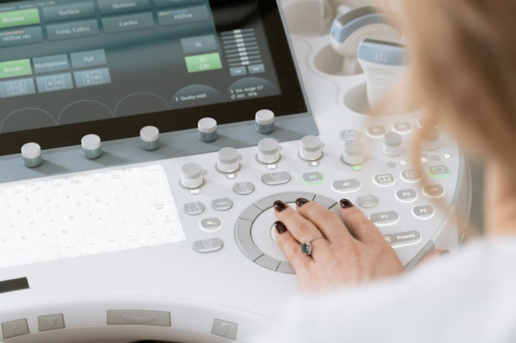 Close-up of a healthcare professional using a diagnostic ultrasound machine.