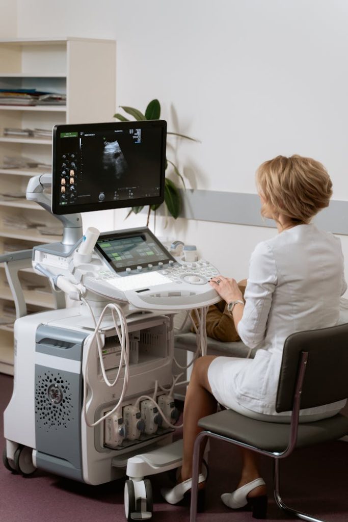 A medical professional operates an ultrasound machine in a clinic setting.